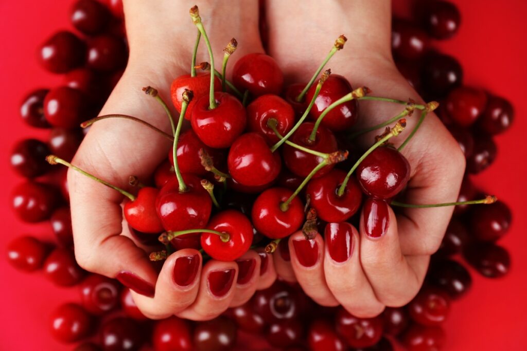 Unghie con smalto color rosso ciliegia
