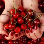 Unghie con smalto color rosso ciliegia