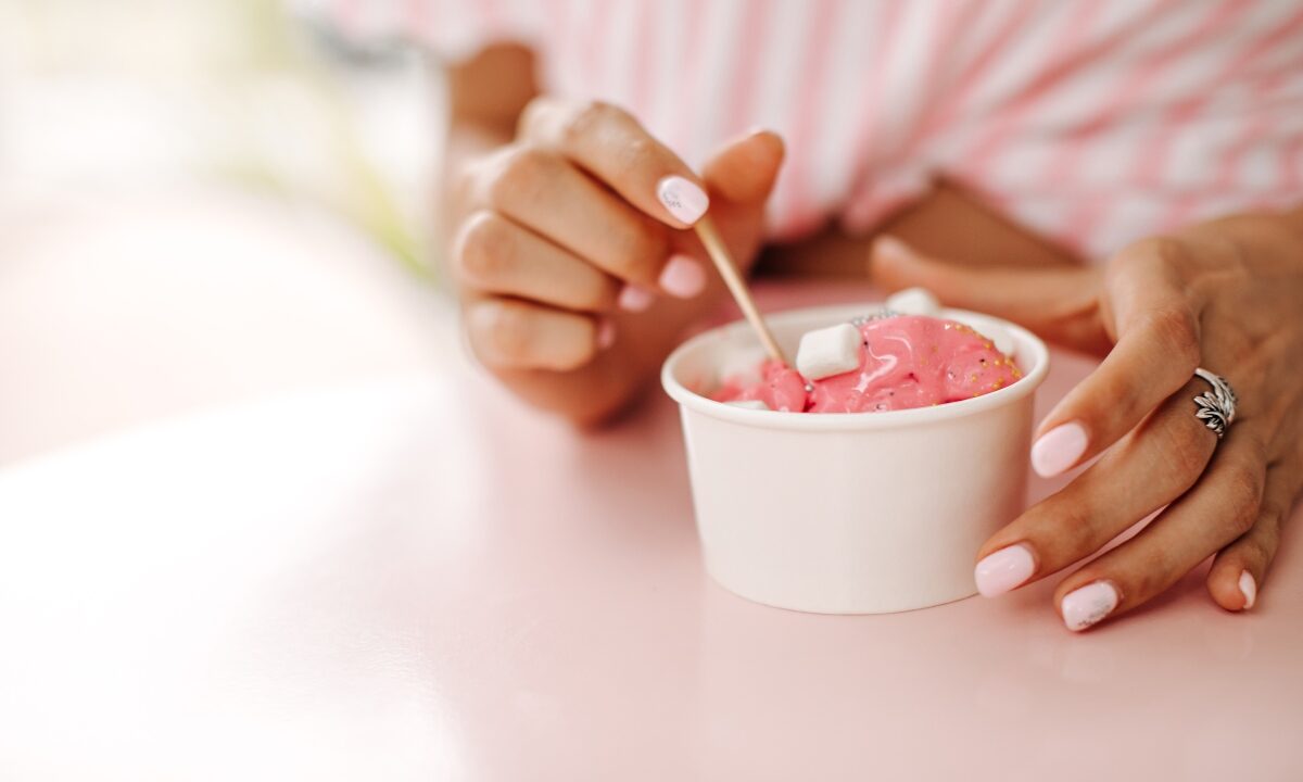 Ragazza con una coppetta di gelato in mano