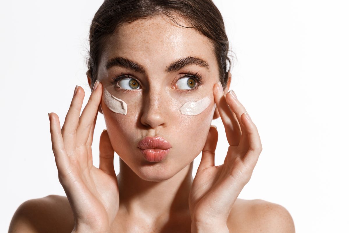 Ragazza applica crema viso sulla pelle