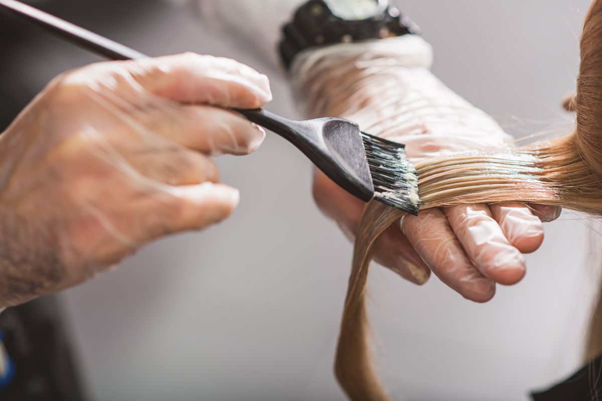 Applicazione di tinta sui capelli da parte del parrucchiere.
