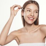 Applicazione di siero viso da parte di una ragazza