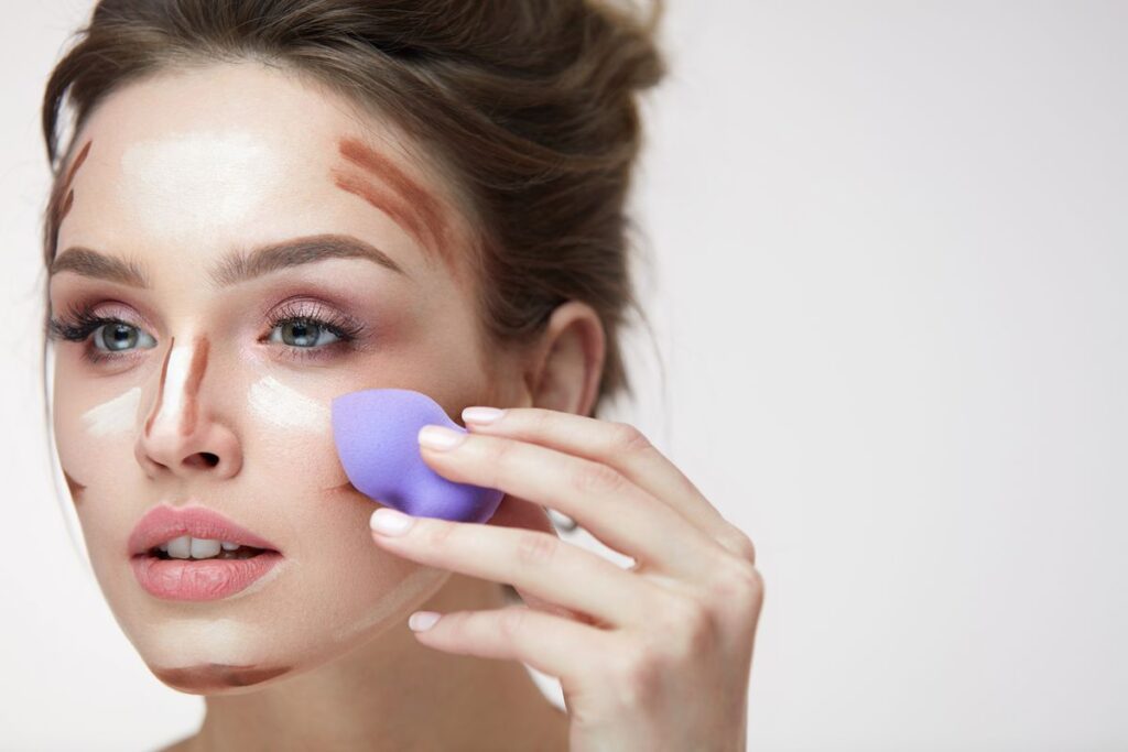 Ragazza si trucca con la tecnica del contouring.