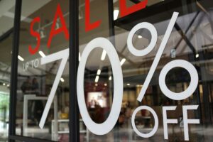 Promozioni stagionali indicate nella vetrina di un negozio