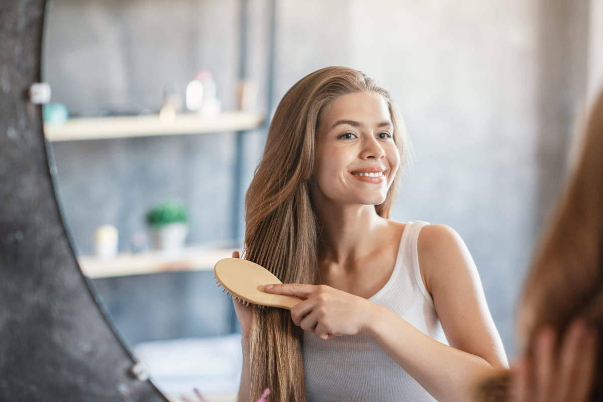 Giovane donna mentre si pettina i capelli.