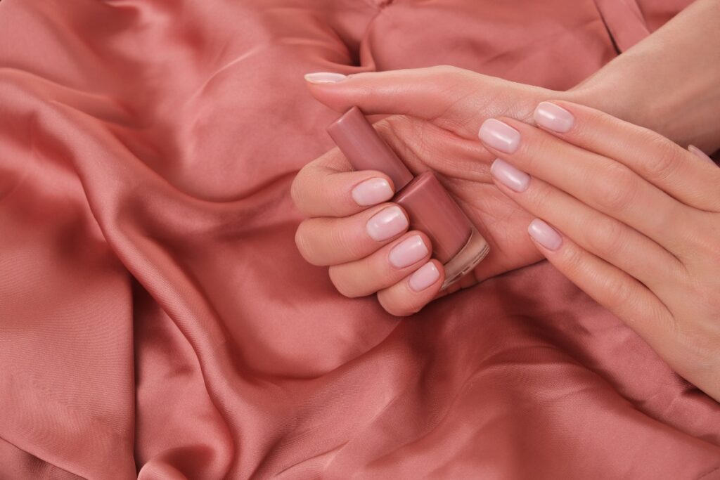 Dettaglio di manicure con finitura rosa.