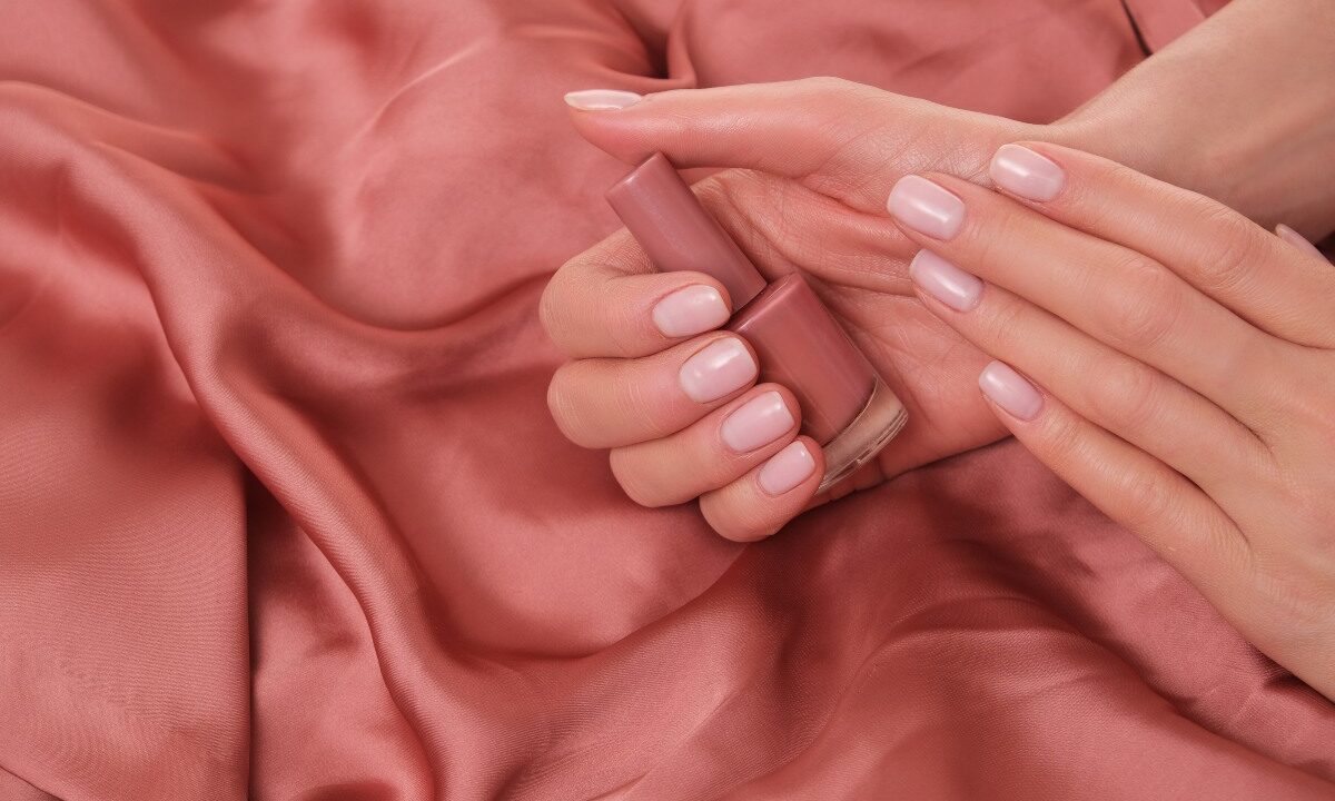 Dettaglio di manicure con finitura rosa.