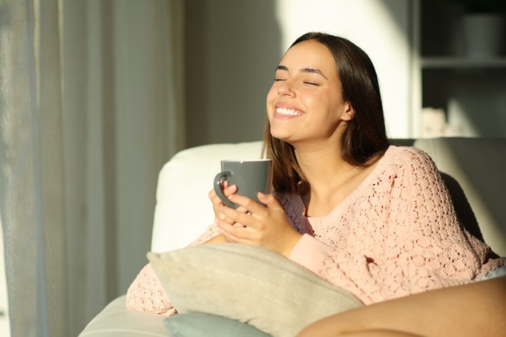 Giovane donna sorridente con una tazza di tisana