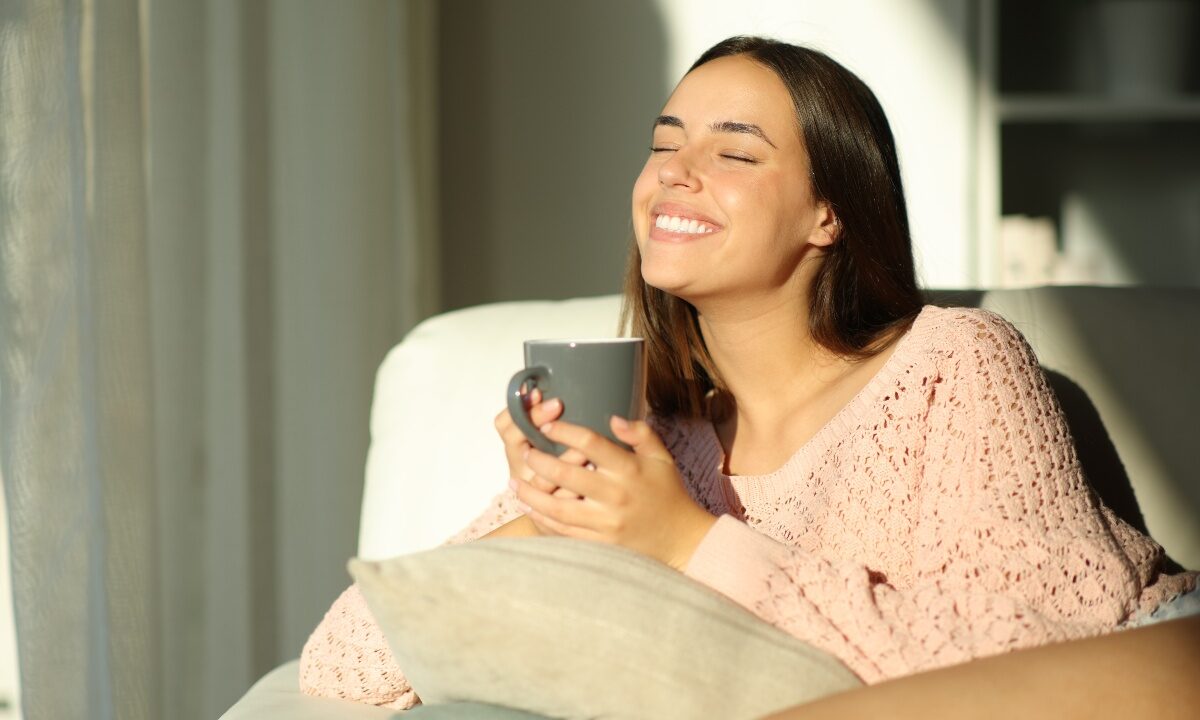 Giovane donna sorridente con una tazza di tisana