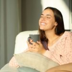 Giovane donna sorridente con una tazza di tisana