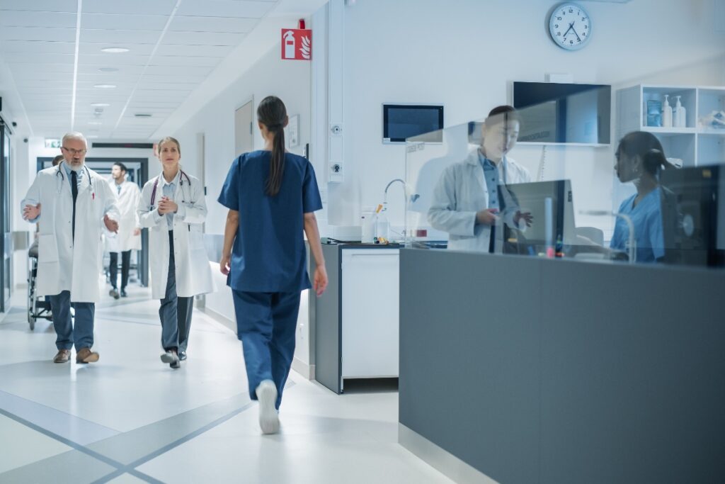 Medici e infermieri ripresi mentre camminano lungo un corridoio d'ospedale.