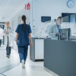 Medici e infermieri ripresi mentre camminano lungo un corridoio d'ospedale.