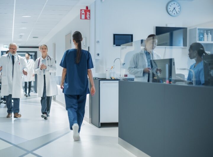 Medici e infermieri ripresi mentre camminano lungo un corridoio d'ospedale.